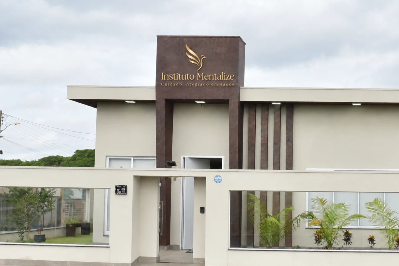 Fachada do Instituto Mentalize em Jataí, com o totem amadeirado e o logo em dourado